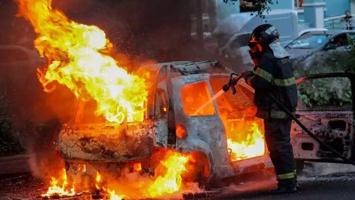 Bombeiro controlando fogo em carro cg